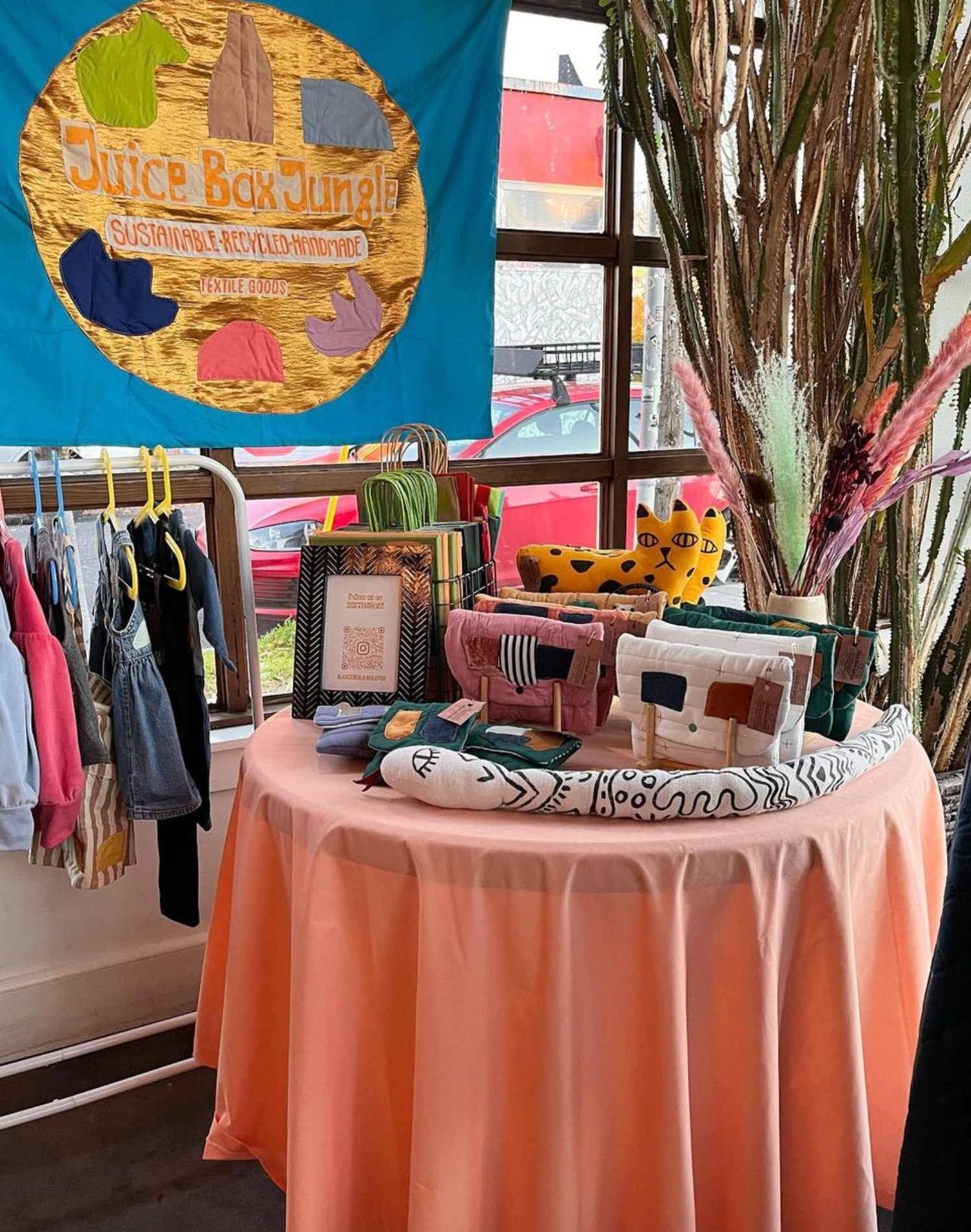 Juice Box Jungle set up in a store featuring handmade clutches, snakes, and kids clothes